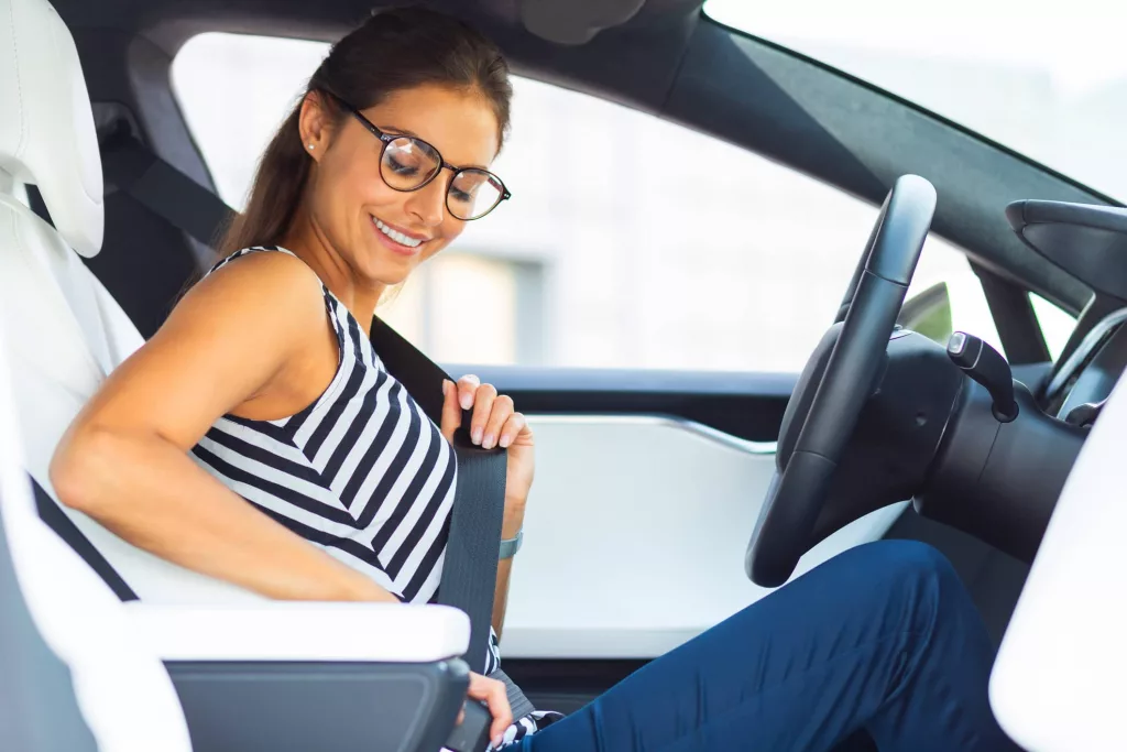 woman-wearing-glasses-sitting-in-her-car-and-fastening-seat-belt-2
