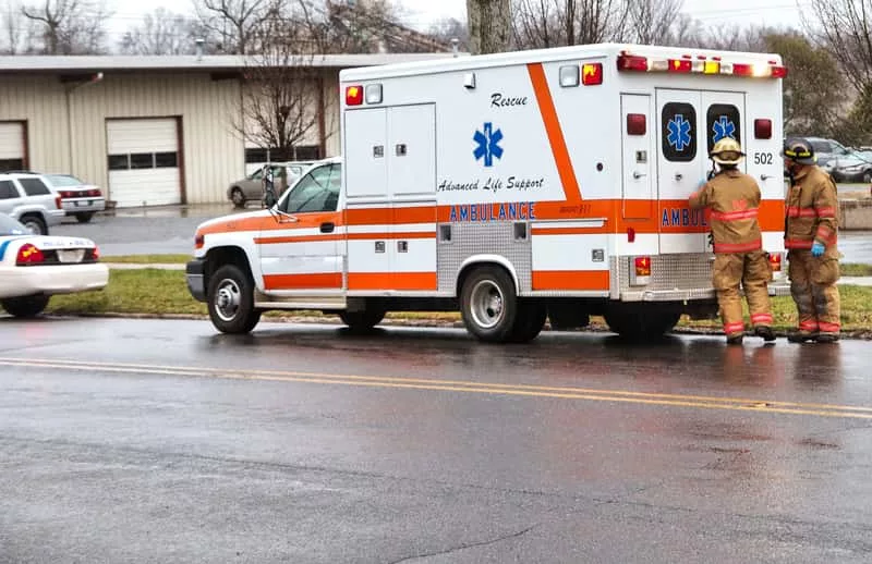 a-couple-of-firemen-at-the-rear-of-an-ambulance