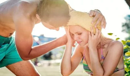 man-helping-woman-in-bikini-with-heatstroke-summer-heat