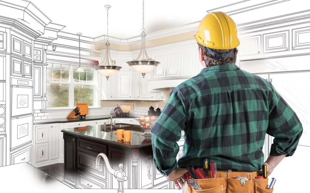 male-contractor-with-hard-hat-and-tool-belt-looking-at-custom-kitchen-drawing-photo-combination-on-white