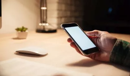 man-hand-holding-blank-screen-mobile-phone-ath-the-table