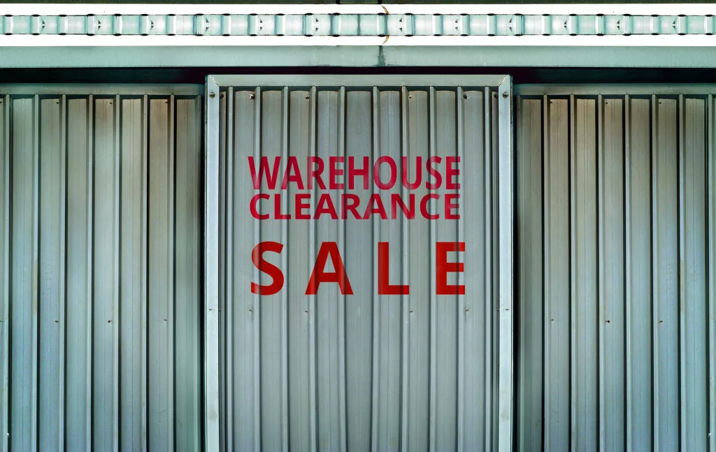 warehouse-clearance-sale-sign-in-metal-wall-background