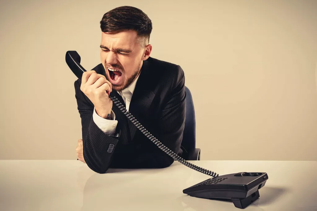 young-man-dials-the-phone-number-while-sitting-in-the-office