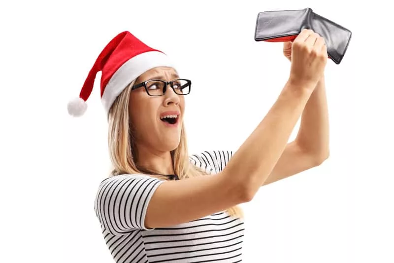 disappointed-woman-with-a-christmas-hat-holding-an-empty-wallet