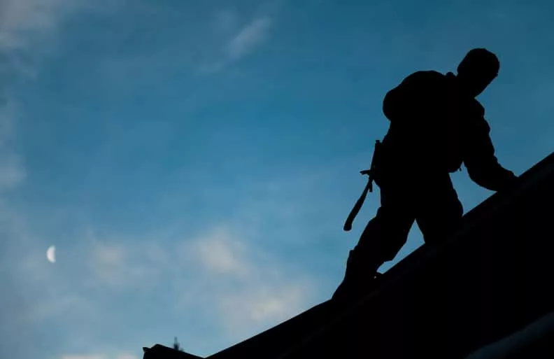 contractor-in-silhouette-working-on-a-roof-top