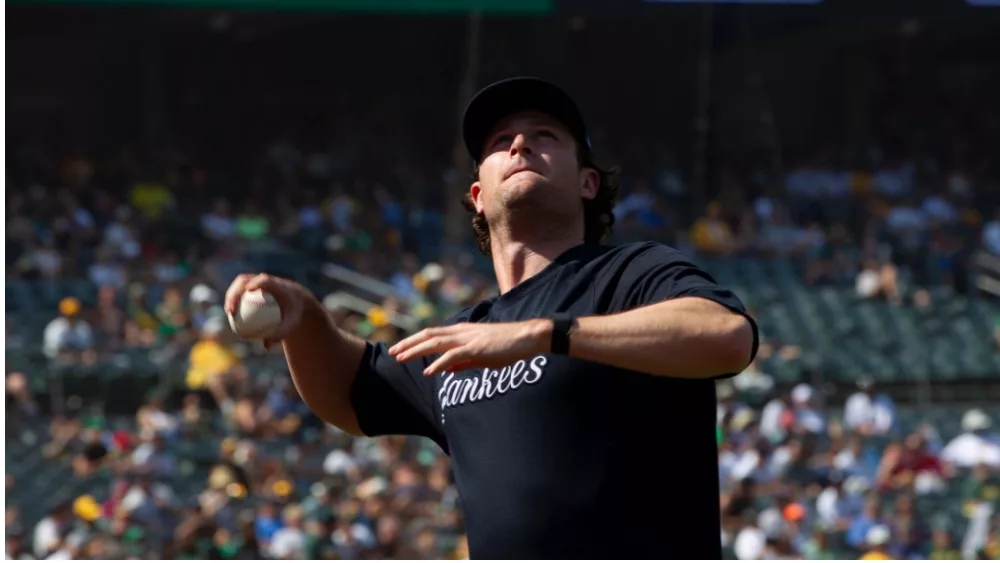 New York Yankees' Gerrit Cole throws a foul ball over the net into the stands during a game against Oakland Athletics at RingCentral Coliseum. Oakland^ California - August 28^ 2021