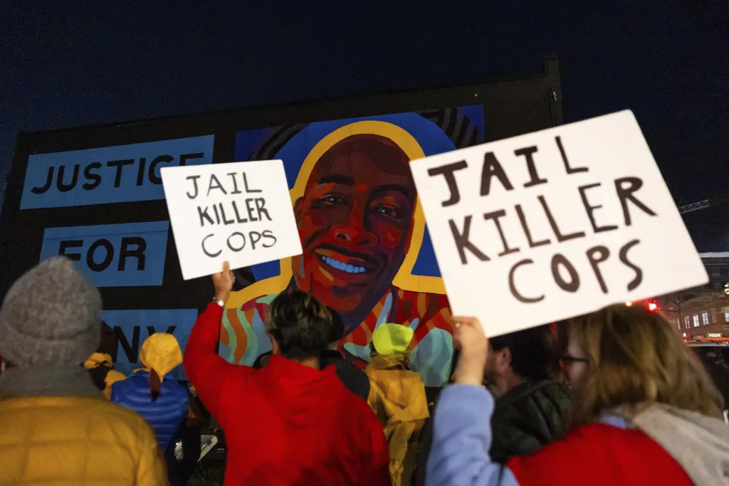 Protesters hold signs at a rally after the verdict was read during the trial of three Tacoma Police officers in the death of Manny Ellis, at Pierce County Superior Court, Thursday, Dec. 21, 2023, in Tacoma, Wash. (AP Photo/Maddy Grassy)