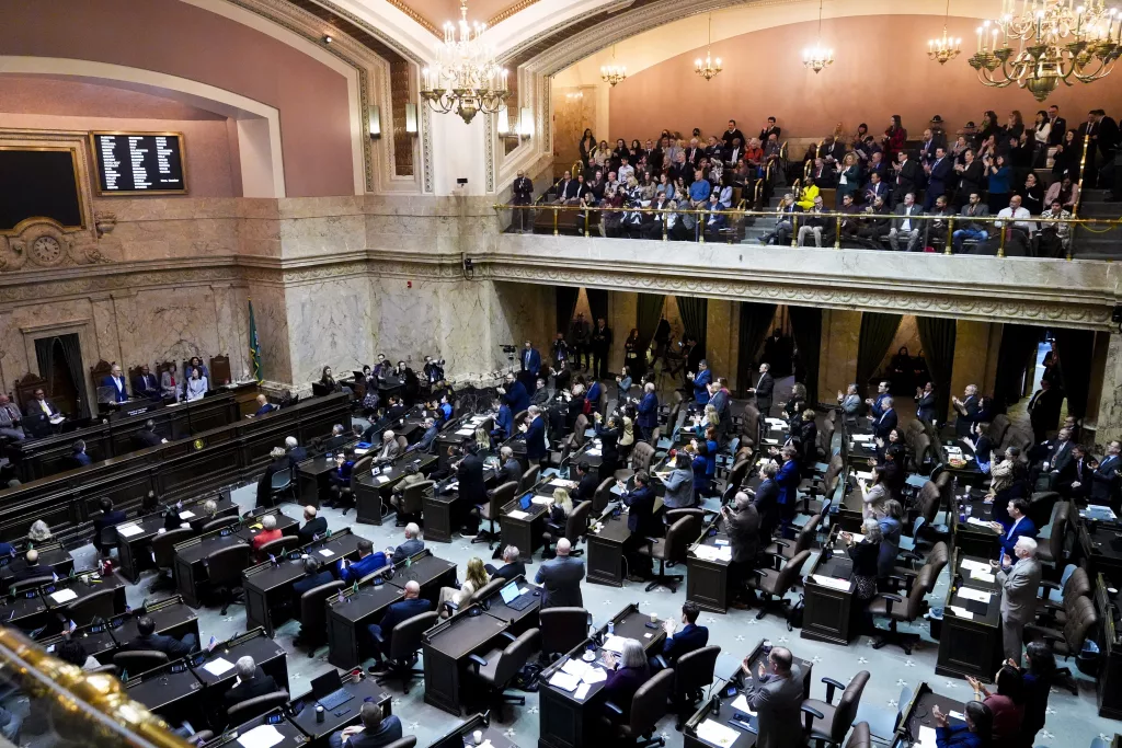 Guests and lawmakers listen as Washington Gov. Jay Inslee delivers his final State of the State address to a joint legislative session in House chambers at the Washington State Capitol, Tuesday, Jan. 14, 2025, in Olympia, Wash. (AP Photo/Lindsey Wasson)
