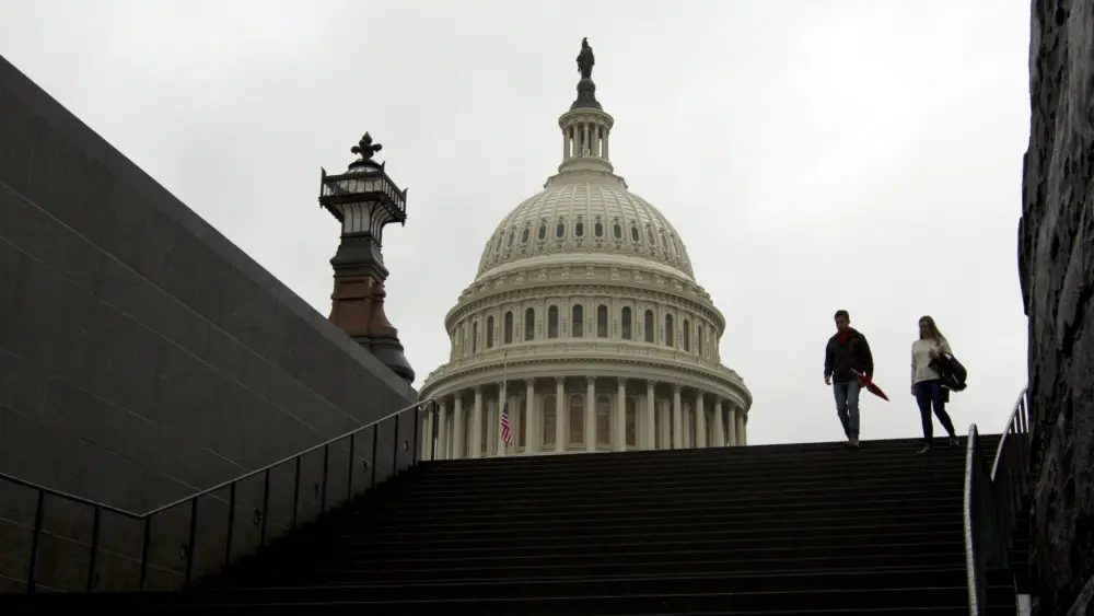 People walk outside of The U.S. Capitol in Washington, Friday, Dec. 21, 2018. Republican-led House approved funding for President Donald Trump's border wall in legislation that pushes the government closer to a partial government shutdown. The bill now goes to the Senate. (AP File Photo/Jose Luis Magana)