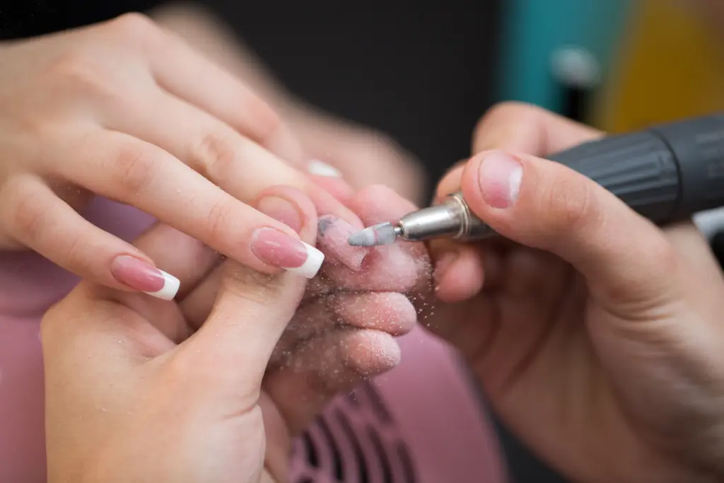 shot-of-master-uses-an-electric-machine-to-remove-the-nail-polish-during-manicure-in-the-salon