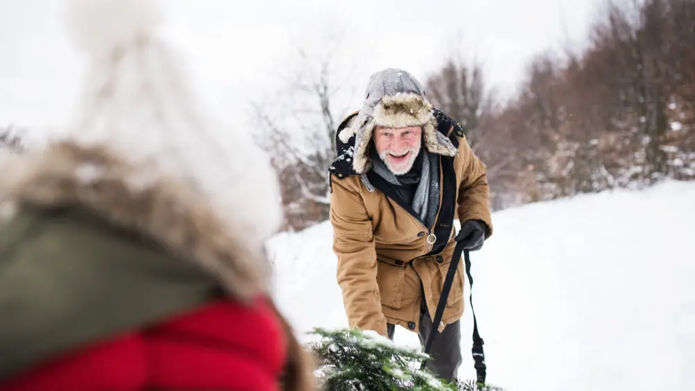 grandfather-and-small-girl-getting-a-christmas-tree-in-forest