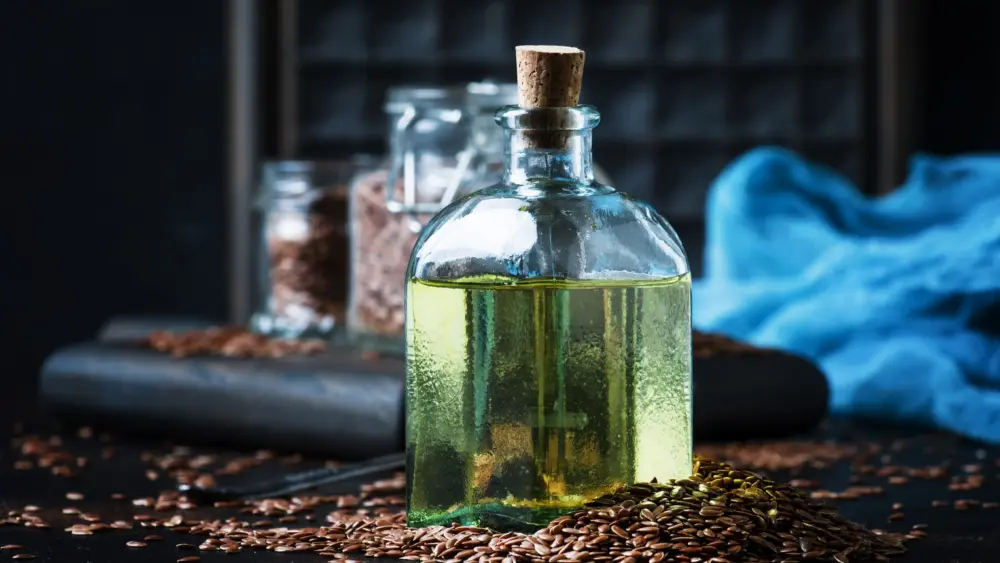 linseed-or-flax-oil-in-glass-bottle-and-seeds-dark-background