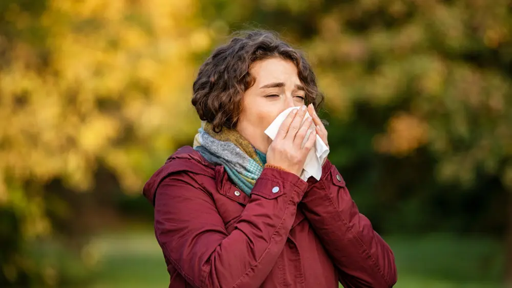 woman-in-park-sneezing-and-blowing-nose