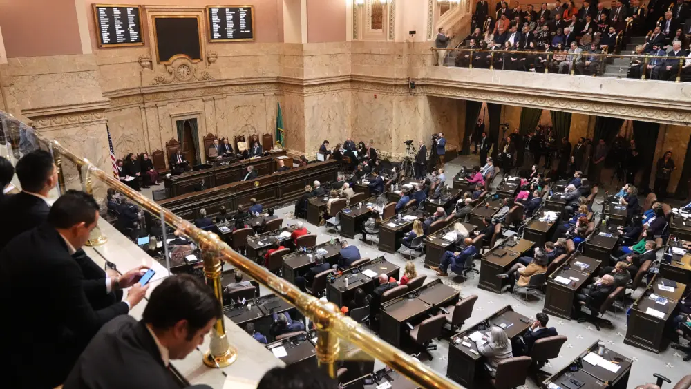 People watch from the gallery as Washington Gov. Bob Ferguson delivers his State of the State address to a joint legislative session at the Washington State Capitol, Tuesday, Jan. 13, 2026, in Olympia, Wash. (AP Photo/Lindsey Wasson)