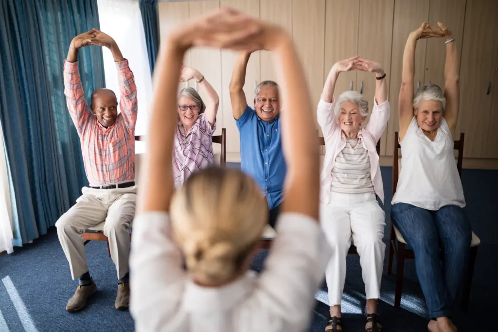 cheerful-senior-men-and-women-exercising-with-female-doctor