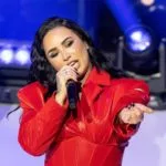 Demi Lovato wearing dress by Michael Ngo performs on stage during American Heart Association Go Red for Women and Red Dress Collection Concert at Jazz at Lincoln Center in New York on Jan 31^ 2024.