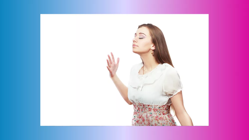 A lady smelling a room against a white background.