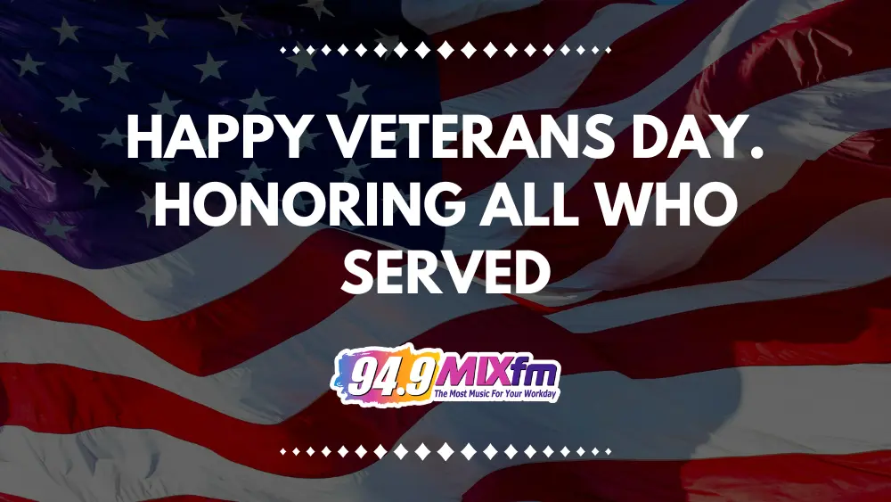 “Waving American flag background with white decorative diamond accents. Large white text reads ‘Happy Veterans Day. Honoring all who served.’ 94.9 MIXfm logo with tagline ‘The Most Music For Your Workday’ at the bottom center.”