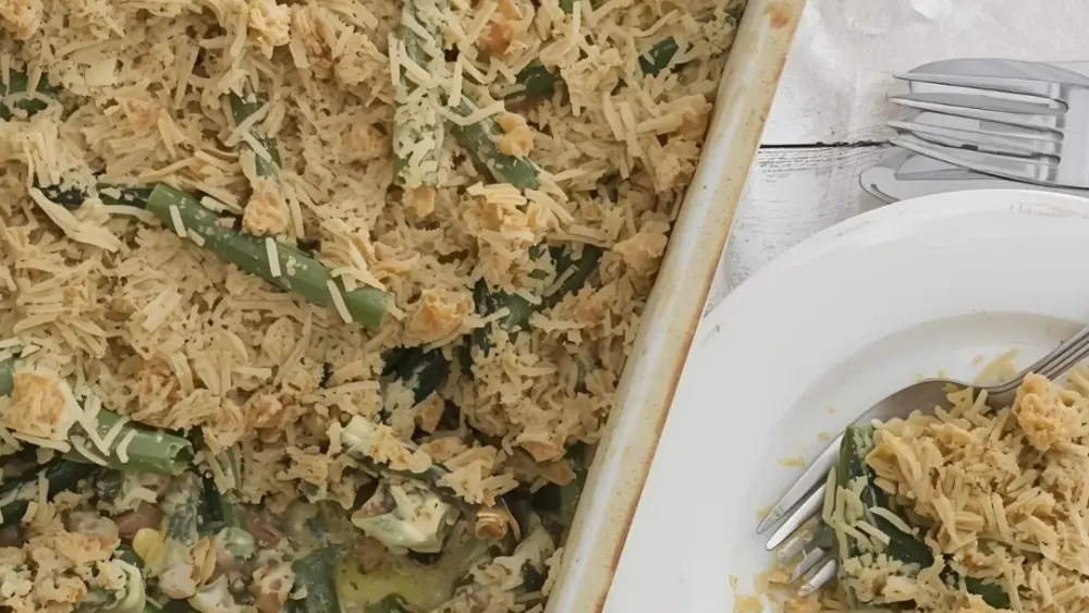 A nasty looking green bean casserole in a dish with a plate next to it.