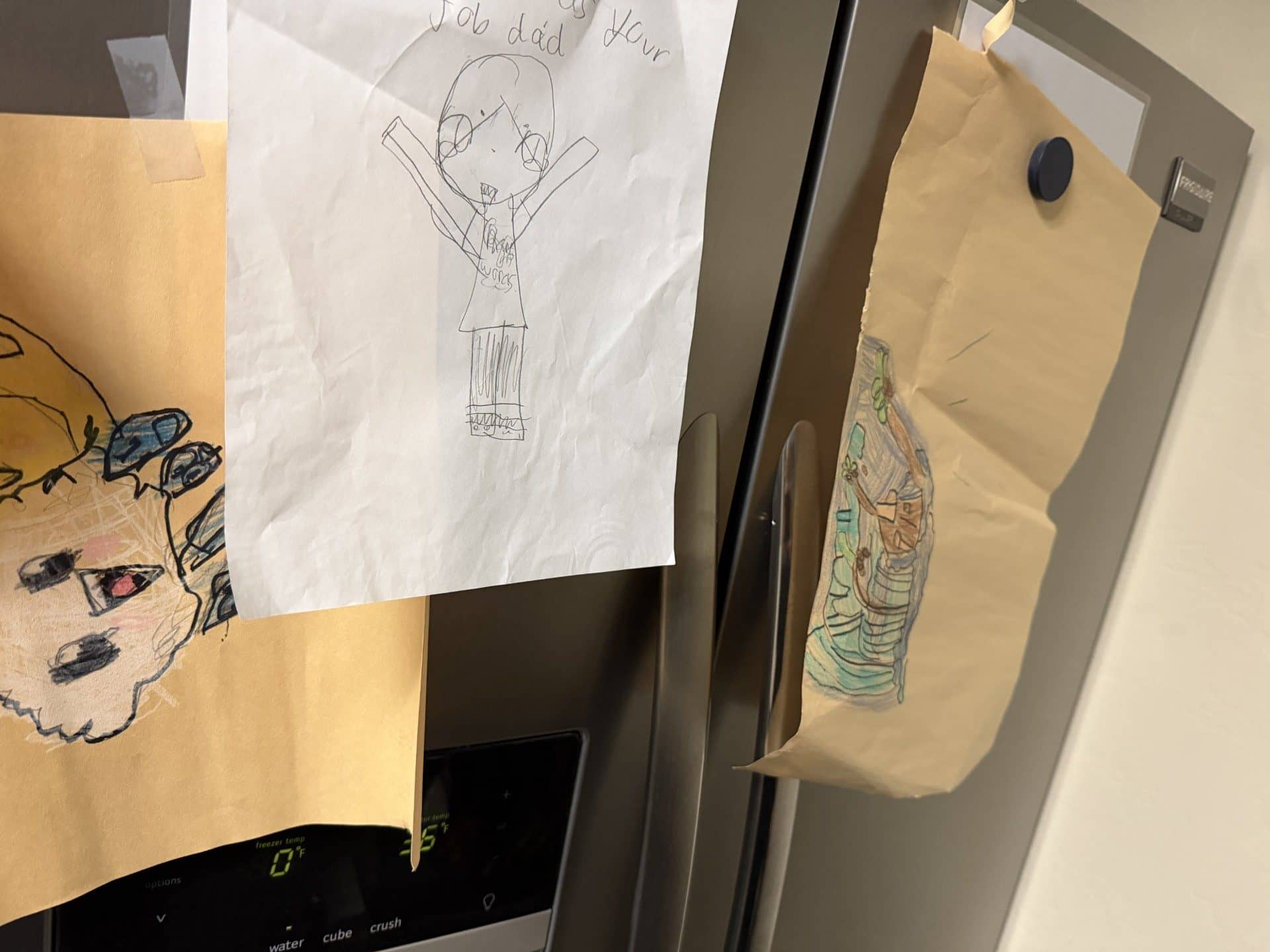 Example photo of a child’s drawing displayed on a refrigerator, showing what kind of image to submit