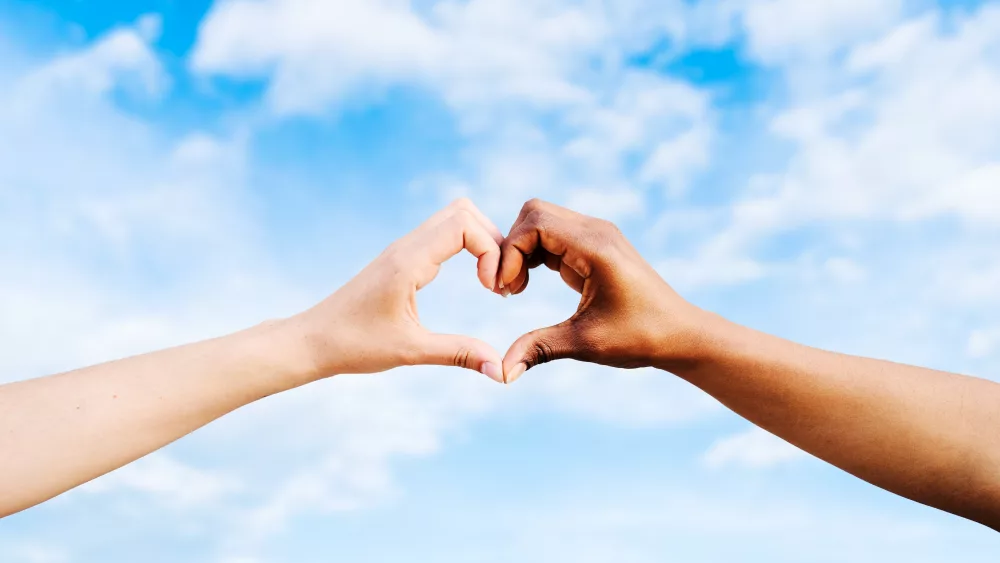 two-multiethnic-hands-join-together-to-form-a-shape-heart-with-a-blue-sky-clouds-background-concept-of-hope-and-love-between-different-races-peace-between-humans-and-against-hatred-and-racism-2