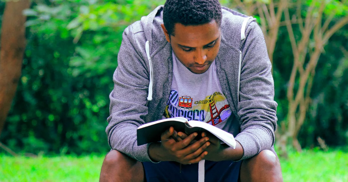 11508-african-american-man-reading-book-outdoors-un126131