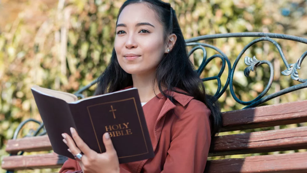 6792-asian-woman-happy-reading-bible-gettyimages-y797703
