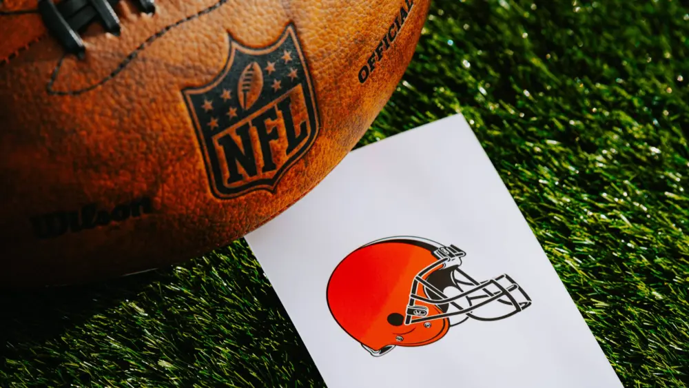 Cleveland Browns NFL team Logo and American football ball on Green Grass.