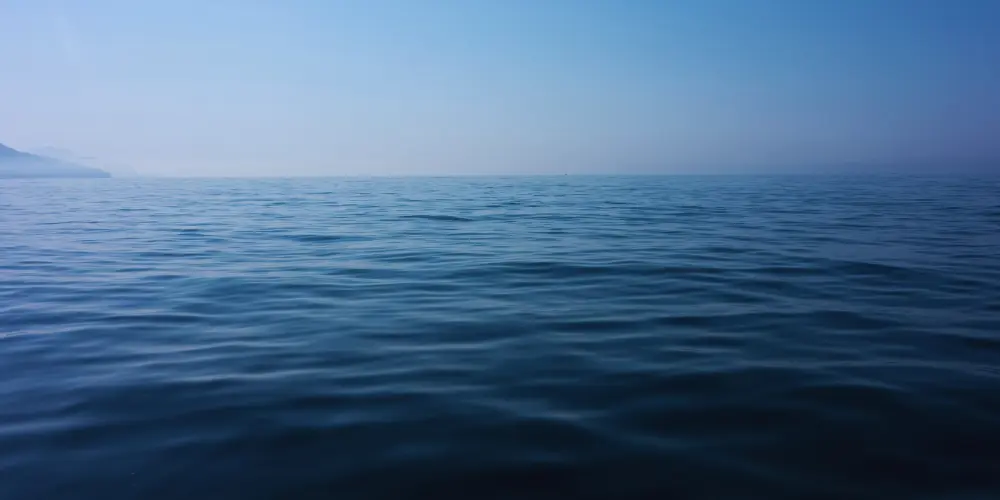 The surface of an ocean at dusk.