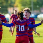 Massac County's Kyle Hannan (21) and Lathan Harris (9) celebrate Joseph Gomez's (10) goal against Murphysboro. Photo by Hunter Whitecotton/Southern Focus Photography