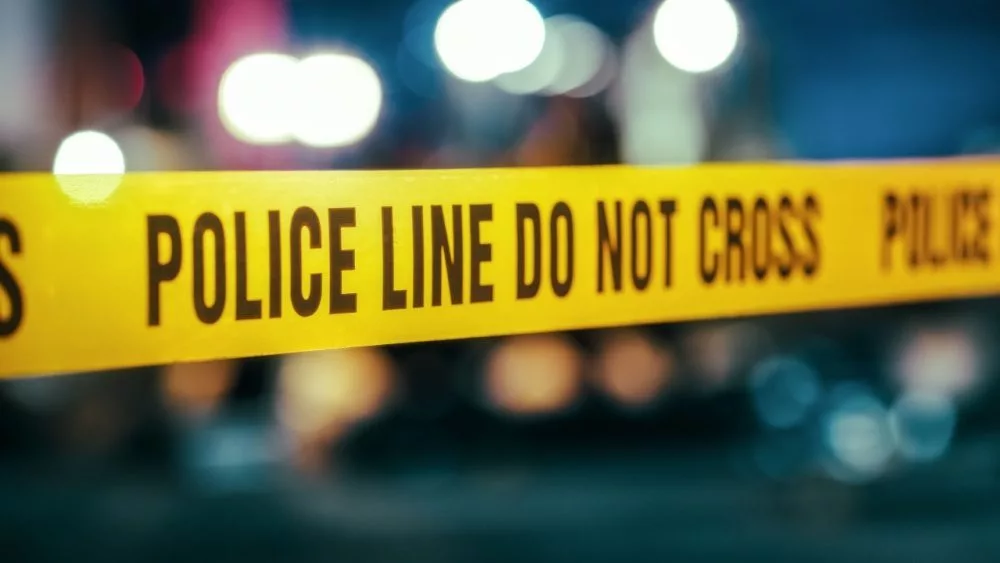 Yellow Tape Showing Text "Police Line Do Not Cross" Restricting a Crime Scene Area At Night. Close Up Aesthetic Shot with Bokeh Effect and Flickering Lights.