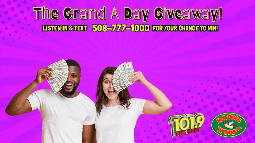 The Grand A Day Giveaway Slider Graphic, showing two young adults waving cash in their hands.