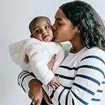 African-American mother kissing her young child