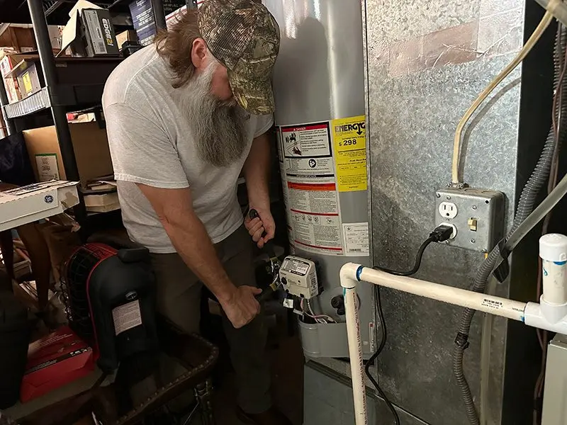 Owner Adam Ladu repairing a water heater