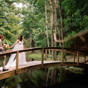 Bride and Groom on Bridge in Woods