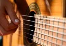 A woman plays an acoustic guitar.