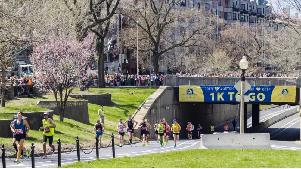 Runners in the Boston Marathon pass the 1 kilometer to go line on their way to the finish line