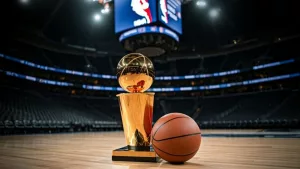Indoor photo of photography of a basketball and next to it the larry o’brien nba championship trophy lying on a basketball court in an nba arena