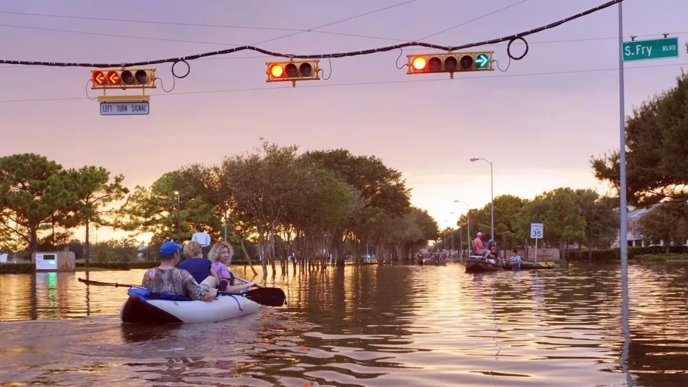 Working traffic lights over flooded Houston streets and boats with people at sunset. Texas^ USA