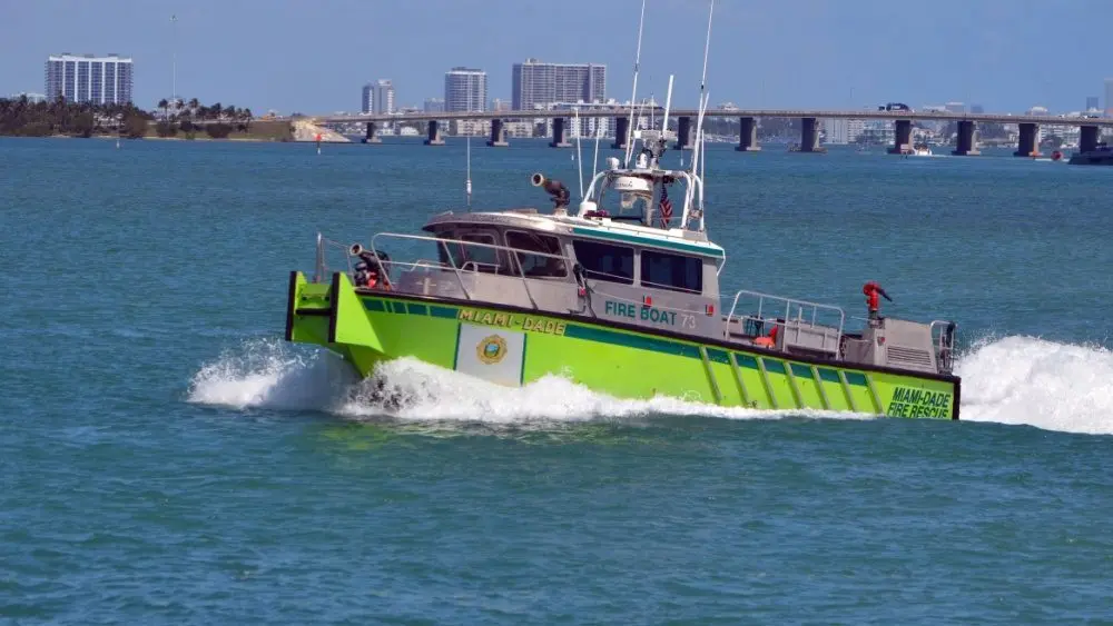Miami-Dade fire-rescue boat patrolling on Biscayne Bay with Julia Tuttle causeway bridge in the distant background. Miami Beach^Florida^U.S.A. 13 March2021