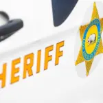 Close-up of a Los Angeles County Sheriff's Department badge and lettering on the side of a patrol vehicle. 2024-11-15 Los Angeles USA