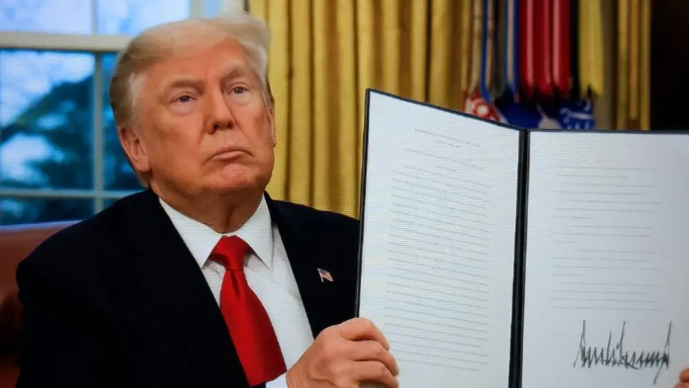 President Donald Trump signs executive orders in the Oval Office of the White House on January 20^ 2025 in Washington^ DC. Trump takes office for his second term