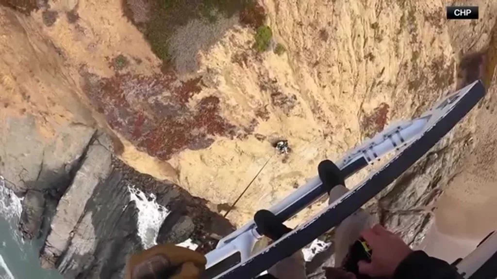 VIDEO: A man dangling from a cliff is rescued by first responders in a helicopter
