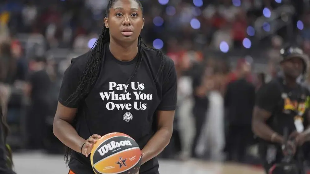 WNBA All-Stars wearing 'Pay us what you owe us' shirts