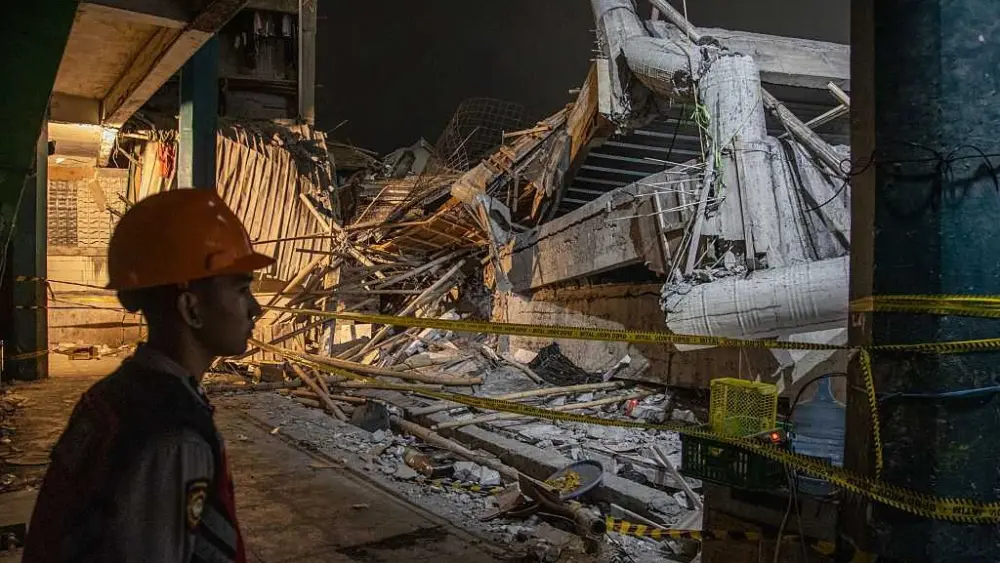 Rescuers run oxygen to survivors in Indonesia school building collapse that buried dozens