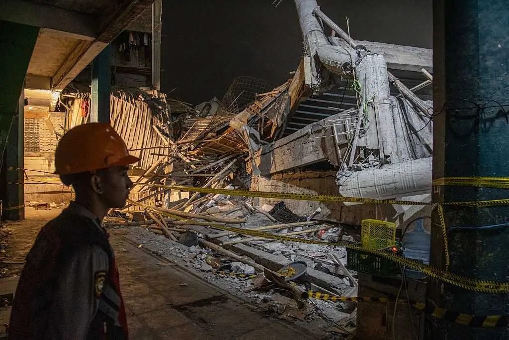 Rescuers run oxygen to survivors in Indonesia school building collapse that buried dozens
