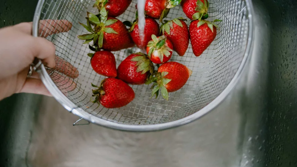 high-angle-view-of-rinsing-strawberries-in-kitchen-royalty-free-image-1723489983796840