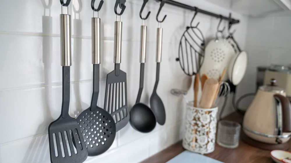 kitchen-utensils-hanging-on-hooks-on-rod-above-royalty-free-image-1727900631527448