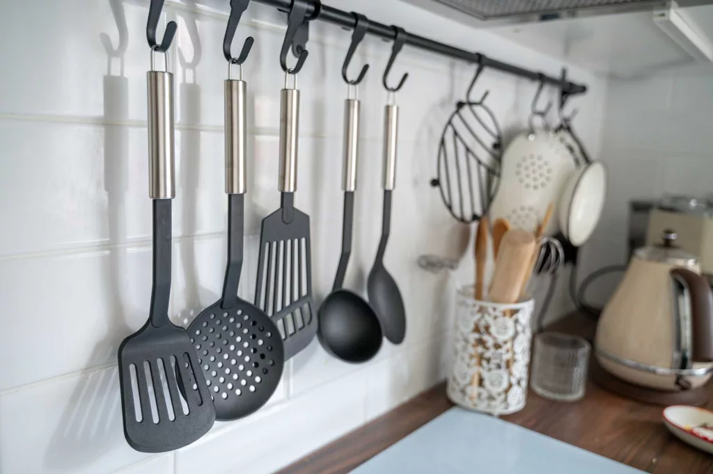 kitchen-utensils-hanging-on-hooks-on-rod-above-royalty-free-image-1727900631527448