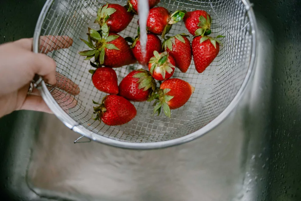 high-angle-view-of-rinsing-strawberries-in-kitchen-royalty-free-image-1723489983687918